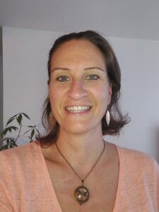 Blandine Coudurier-Dufour, jeune femme souriante, portant un médaillon en forme de libellule.